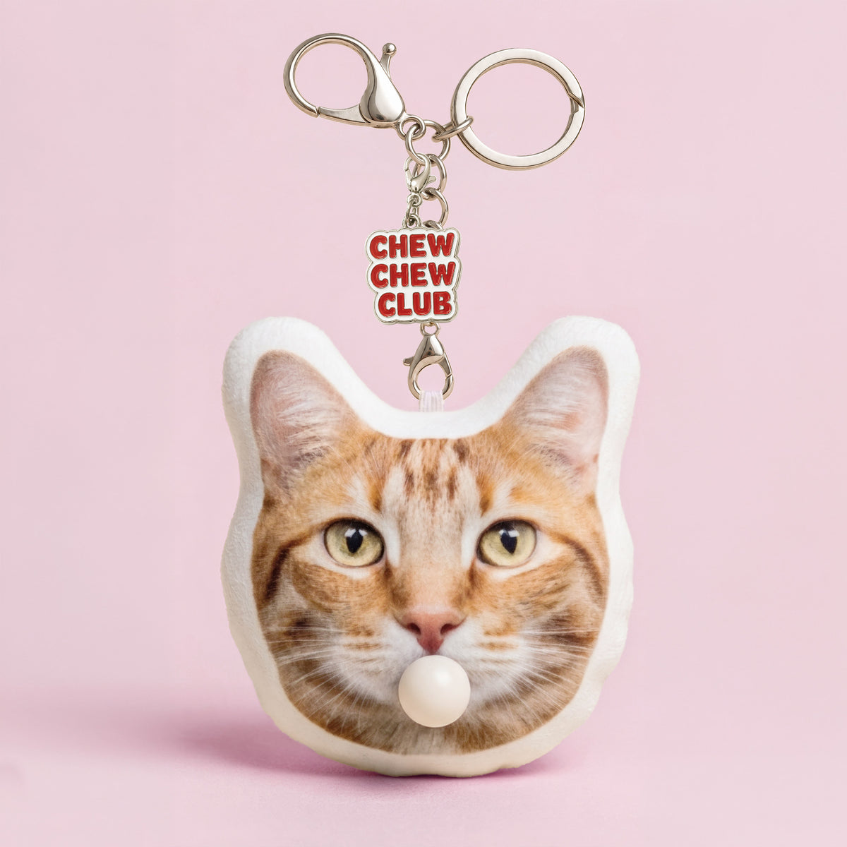 Custom orange tabby cat head plush keychain from a pet photo with bubble-blowing feature and enamel charm